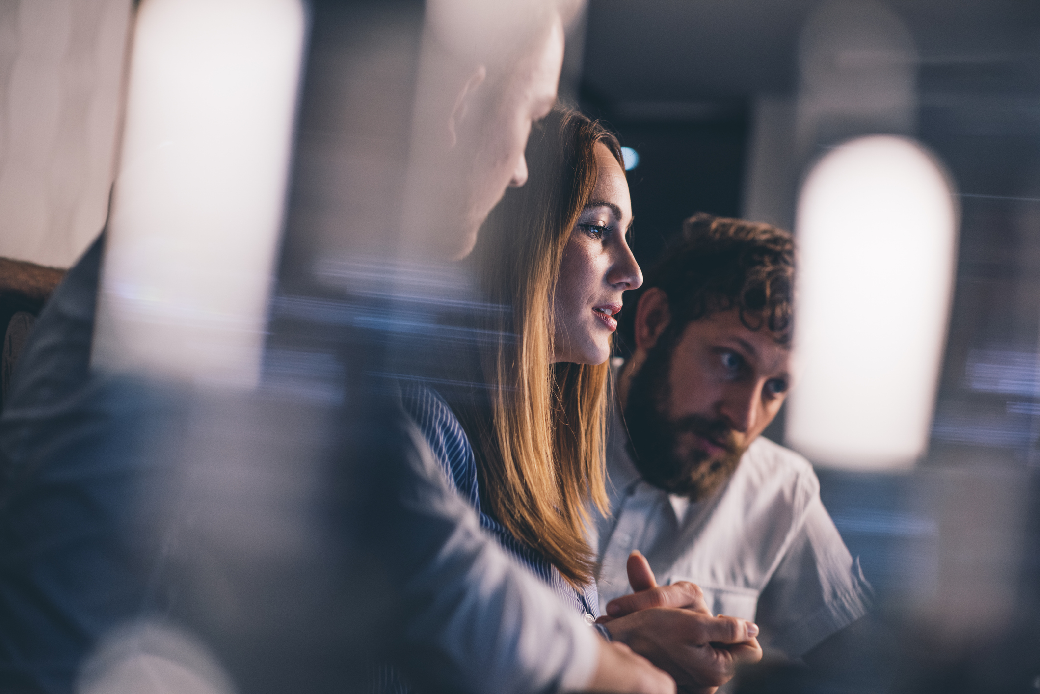Group of 3 people working closely together in front of screen